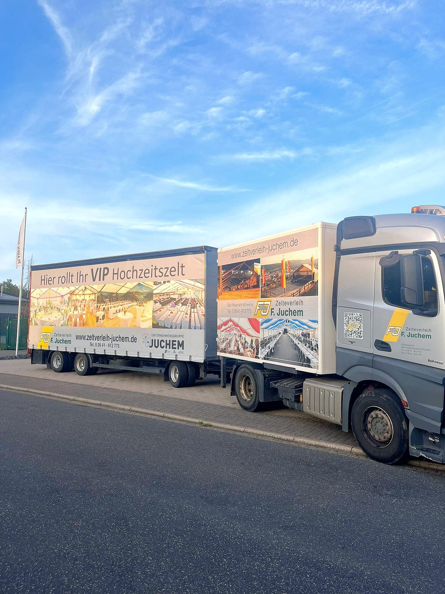 Lkw mit Anhänger im Juchem-Design, Aufschrift „Hier rollt Ihr VIP Hochzeitszelt“